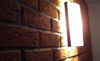 Ściana z cegły (płytki ryflowane) nocą, oświetlone klinkietem